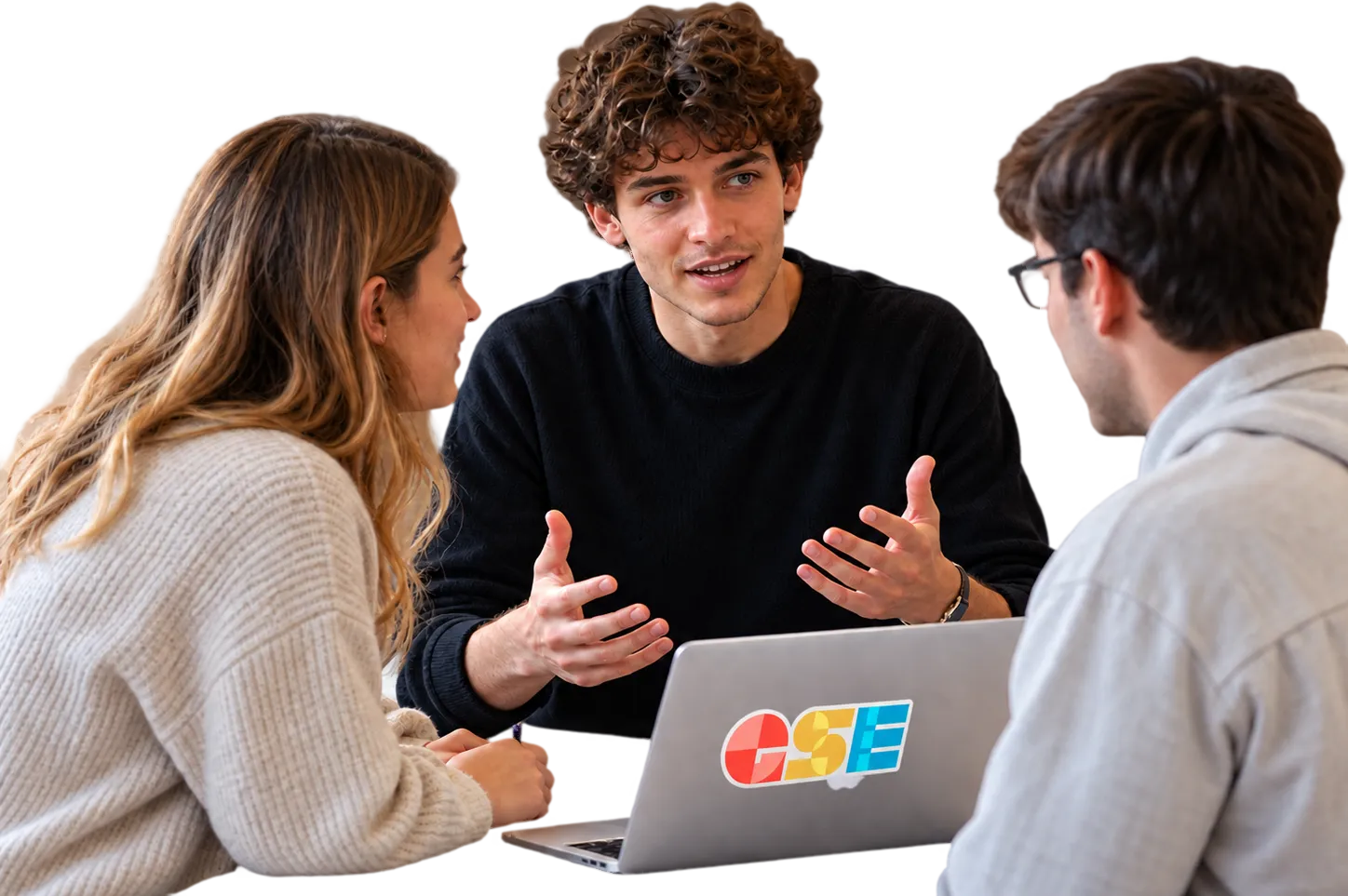 Three students talking around a laptop.